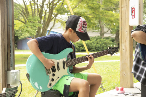 Music - Camp Kid playing guitar