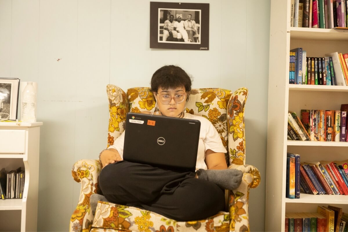 Camper sitting on an armchair while using a laptop