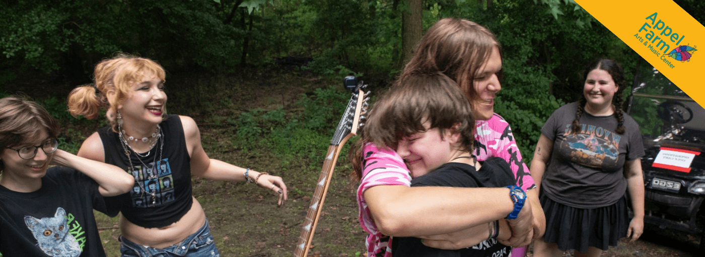 Campers smiling and embracing one another.