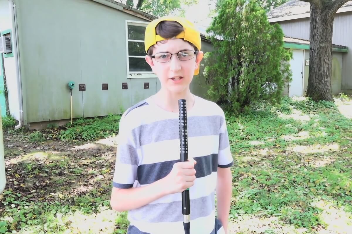 Young kid holding a microphone while reporting