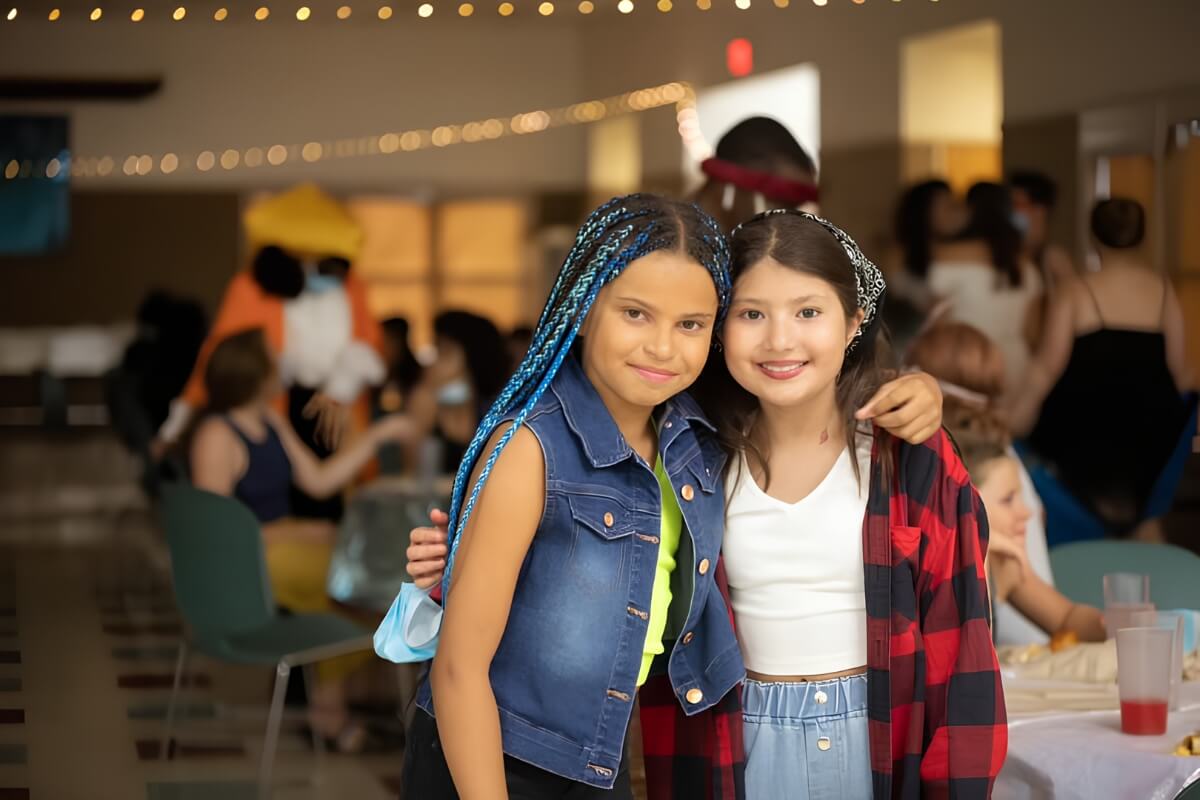 Two children smiling at an Appel Farm arts education program in the dining hall.