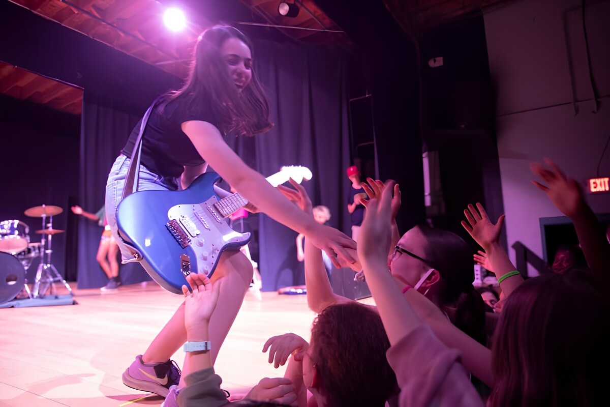 Musician performing on stage and interacting with the crowd.