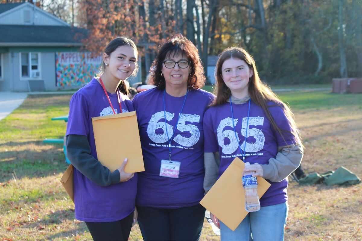 Three people wearing Appel Farm shirts.