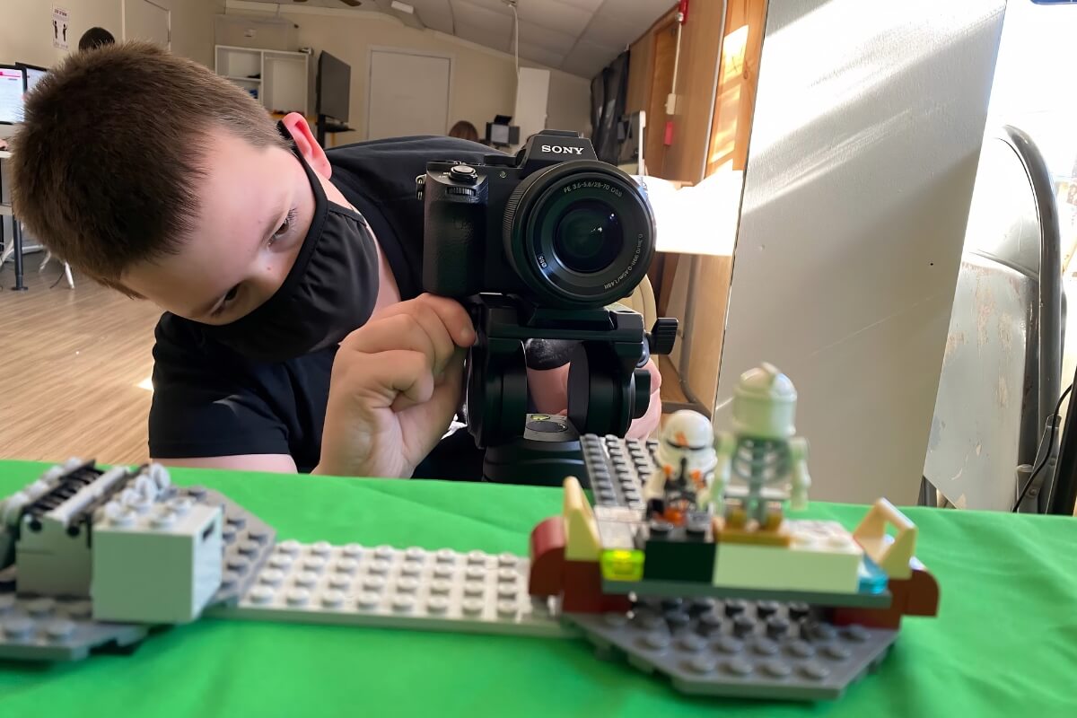 Student taking photos of a LEGO set during school residency.